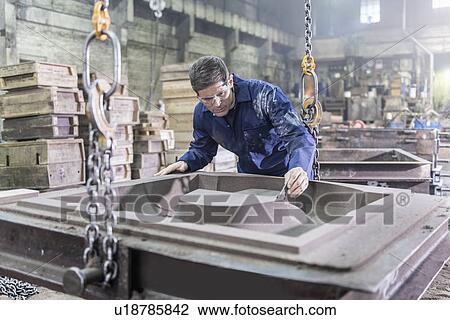 Worker inspecting mould in foundry View Large Photo Image Stock Image - Worker inspecting mould in foundry. Fotosearch