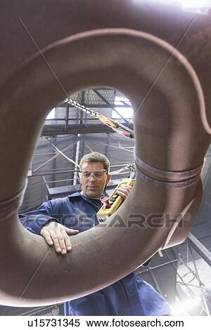 Stock Photography - Worker inspecting mould in foundry. Fotosearch