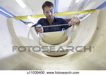 Stock Image - Worker making mould in foundry. Fotosearch