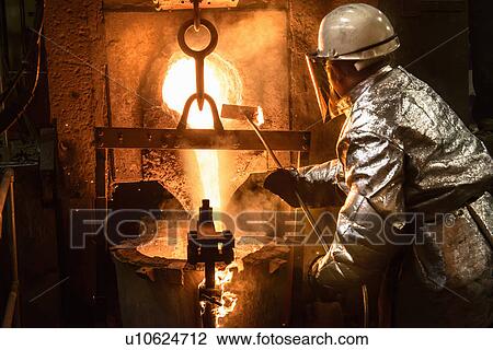 Worker pouring molten metal in foundry View Large Photo Image Stock Image - Worker pouring molten metal in foundry. Fotosearch