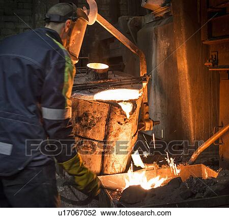 Worker pouring molten metal in foundry View Large Photo Image Stock Image - Worker pouring molten metal in foundry. Fotosearch