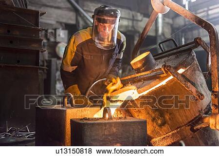 Worker pouring molten metal in foundry View Large Photo Image Stock Photo - Worker pouring molten metal in foundry. Fotosearch