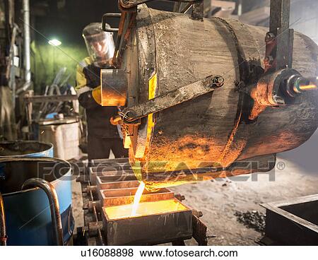 Worker pouring molten metal in foundry View Large Photo Image Stock Photo - Worker pouring molten metal in foundry. Fotosearch