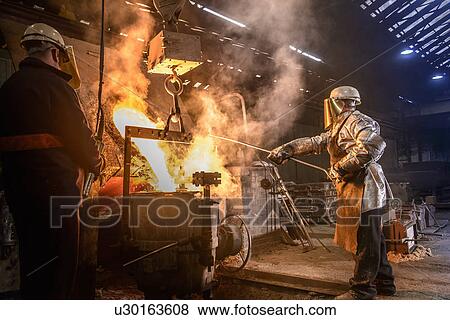 Worker pouring molten metal in foundry View Large Photo Image Stock Photo - Worker pouring molten metal in foundry. Fotosearch