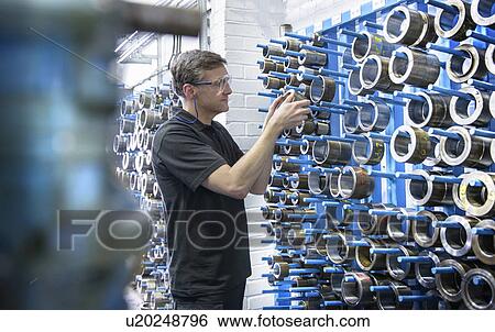 Worker selecting metal coil in factory View Large Photo Image Stock Photograph - Worker selecting metal coil in factory. Fotosearch