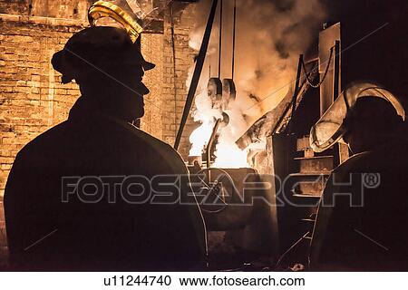 Worker standing in metal foundry View Large Photo Image Stock Image - Worker standing in metal foundry. Fotosearch