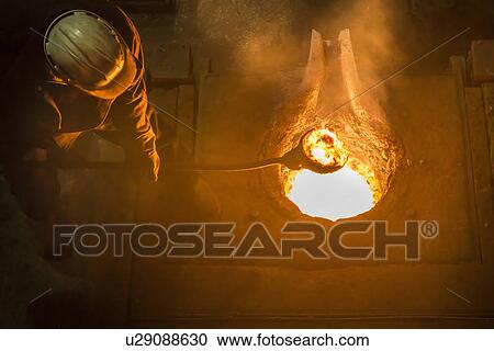 Worker stirring molten metal in foundry View Large Photo Image Stock Image - Worker stirring molten metal in foundry. Fotosearch