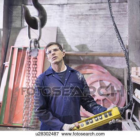 Stock Photo - Worker using equipment in foundry. Fotosearch
