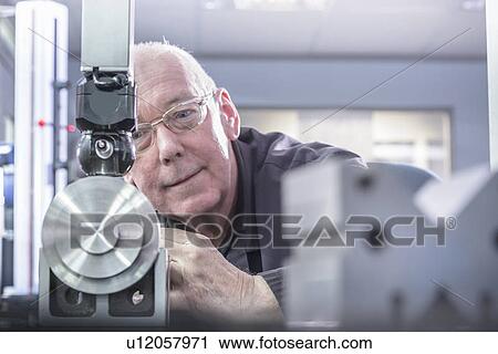 Worker using machinery in factory View Large Photo Image Stock Image - Worker using machinery in factory. Fotosearch