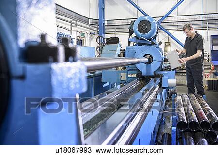 Worker using machinery in factory View Large Photo Image Stock Image - Worker using machinery in factory. Fotosearch