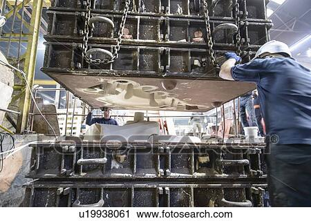Stock Image - Workers fitting top to mould in foundry. Fotosearch