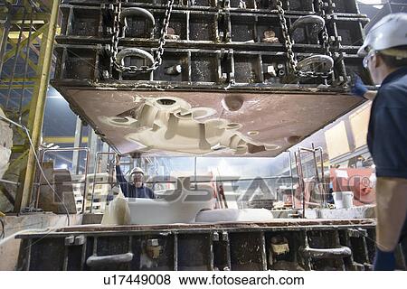 Stock Photo - Workers fitting top to mould in foundry. Fotosearch