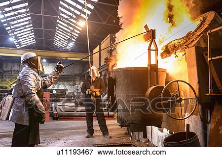 Workers pouring molten metal in factory View Large Photo Image Stock Photo - Workers pouring molten metal in factory. Fotosearch