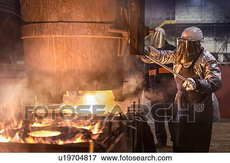 Workers pouring molten metal in factory View Large Photo Image Stock Photo - Workers pouring molten metal in factory. Fotosearch