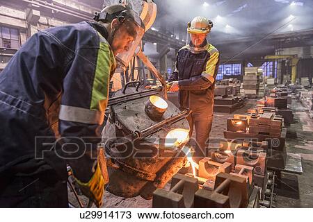 Workers pouring molten metal in foundry View Large Photo Image Stock Image - Workers pouring molten metal in foundry. Fotosearch