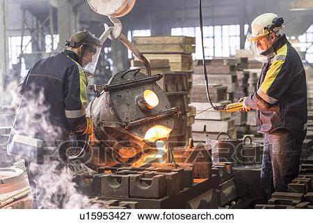 Workers pouring molten metal in foundry View Large Photo Image Stock Photo - Workers pouring molten metal in foundry. Fotosearch