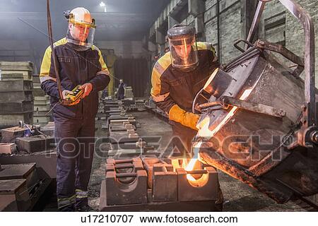 Stock Photo - Workers pouring molten metal in foundry. Fotosearch