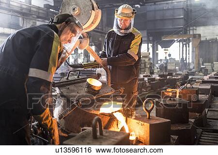 Workers pouring molten metal in foundry View Large Photo Image Stock Photograph - Workers pouring molten metal in foundry. Fotosearch
