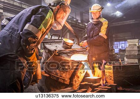 Workers pouring molten metal in foundry View Large Photo Image Stock Photography - Workers pouring molten metal in foundry. Fotosearch
