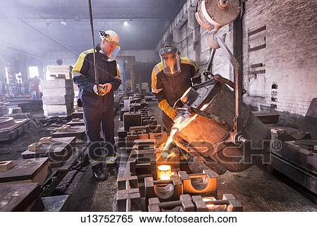 Stock Photography - Workers pouring molten metal in foundry. Fotosearch