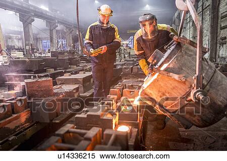 Workers pouring molten metal in foundry View Large Photo Image Stock Photography - Workers pouring molten metal in foundry. Fotosearch