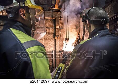 Stock Photo - Workers talking in metal foundry. Fotosearch