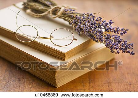 Stock Photo - Antique book with eyeglasses and lavender. Fotosearch