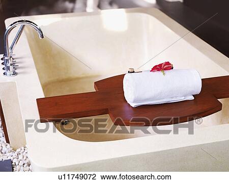 Bathtub with towel on wooden shelf View Large Photo Image Stock Image - Bathtub with towel on wooden shelf. Fotosearch