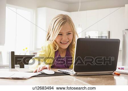 Picture - Blonde girl (6-7) using laptop. Fotosearch