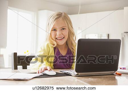 Stock Photography - Blonde girl (6-7) using laptop. Fotosearch