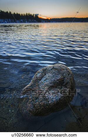 Stock Image - Boulder in water. Fotosearch