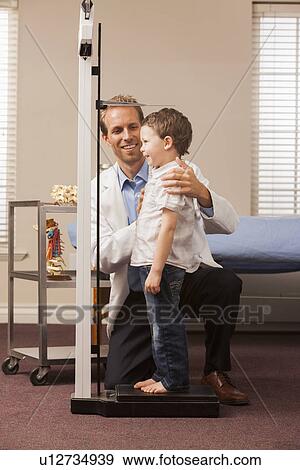 Stock Photo - Boy (2-3) on scale in doctor's office. Fotosearch