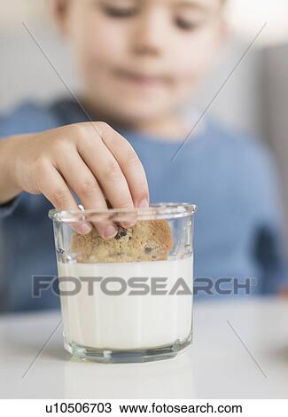 Boy (4-5) dipping cookie in milk View Large Photo Image Stock Image - Boy (4-5) dipping cookie in milk. Fotosearch