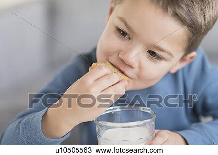 Boy (4-5) eating cookie View Large Photo Image Stock Image - Boy (4-5) eating cookie. Fotosearch