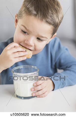 Boy (4-5) eating cookie View Large Photo Image Stock Image - Boy (4-5) eating cookie. Fotosearch