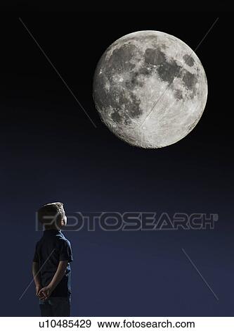 Stock Photo - Boy (4-5) looking at full moon. Fotosearch