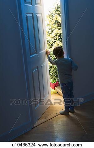 Boy (4-5) peeking through doorway View Large Photo Image Picture - Boy (4-5) peeking through doorway. Fotosearch