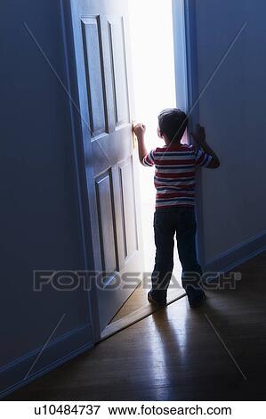 Stock Photo - Boy (4-5) peeking through doorway. Fotosearch