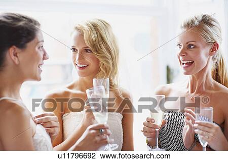 Stock Image - Bride and bridesmaids toasting and talking. Fotosearch
