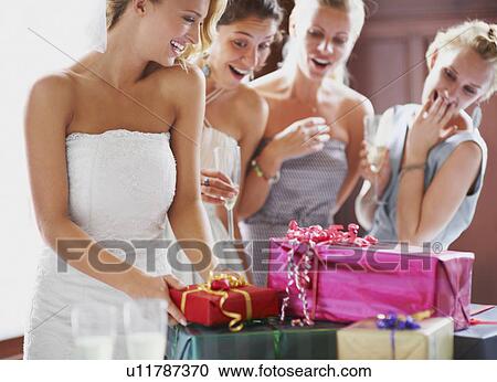 Stock Image - Bride and bridesmaids unpacking gifts. Fotosearch