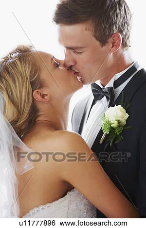 Stock Photograph - Bride and groom kissing. Fotosearch