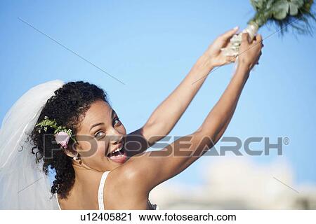 Stock Image - Bride throwing bouquet. Fotosearch