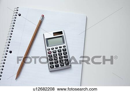 Calculator and pencil on notepad, studio shot View Large Photo Image Stock Photo - Calculator and pencil on notepad, studio shot. Fotosearch