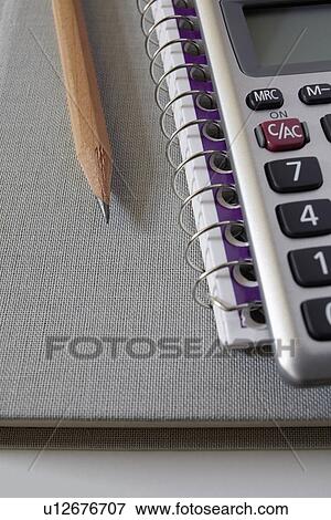 Calculator, textbook and pencil on notebook, studio shot View Large Photo Image Stock Photo - Calculator, textbook and pencil on notebook, studio shot. Fotosearch