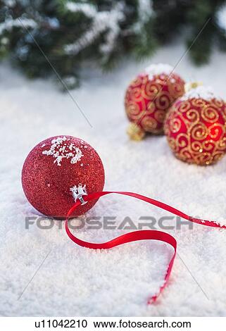 Stock Image - Christmas baubles on snow. Fotosearch