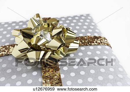 Stock Photo - Close-up of gift with golden ribbon. Fotosearch