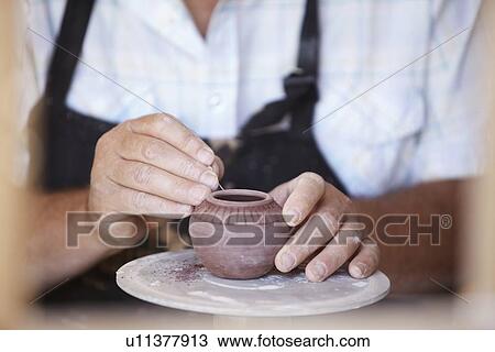 Close-up of male potter holding small vase, carving View Large Photo Image Stock Image - Close-up of male potter holding small vase, carving. Fotosearch