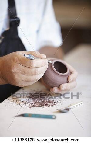 Close-up of male potter holding small vase, carving View Large Photo Image Stock Photo - Close-up of male potter holding small vase, carving. Fotosearch