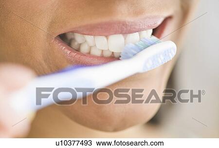 Stock Image - Close-up of woman brushing teeth. Fotosearch