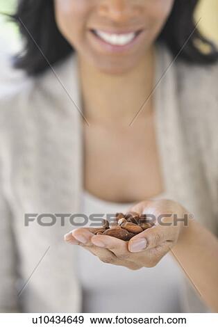 Stock Photo - Close-up of woman holding almonds. Fotosearch